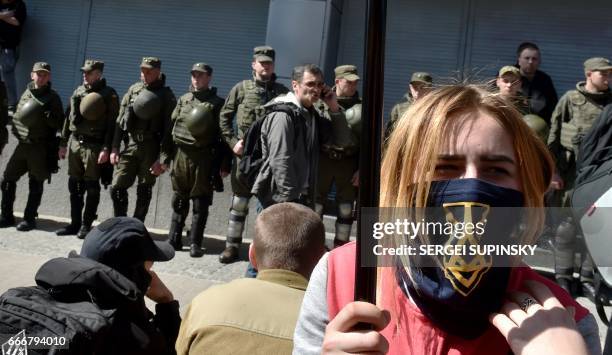 Activists demonstrate in front of Ukrainian National Guard soldiers guarding the Russian owned Sberbank Bank in Kiev on April 10, 2017. Ukrainian...