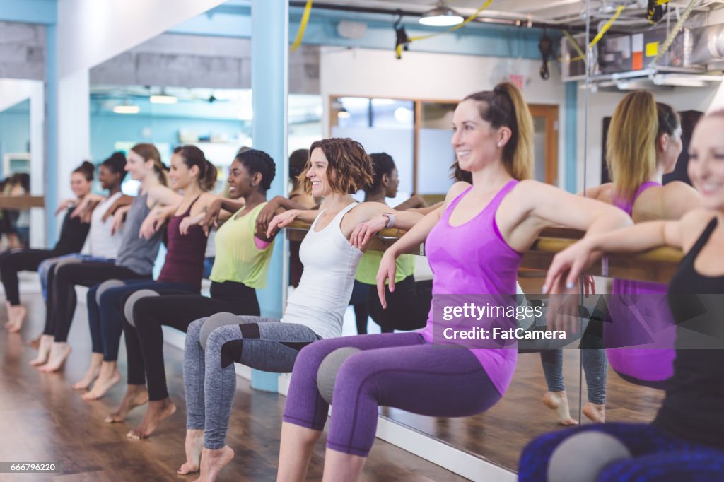 Multi-ethnic group of women doing barre workout