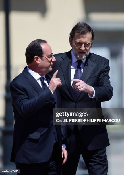 French President Francois Hollande and Spanish Prime Minister Maiano Rajoy chat as they walk on April 10, 2017 at the Palacio del Pardo, near the...