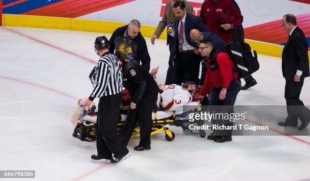 Tariq Hammond of the Denver Pioneers gives a "thumbs-up" as is taken off the ice on a stretcher after he crashed into the boards breaking his ankle...
