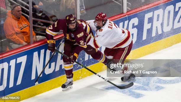 Tariq Hammond of the Denver Pioneers checks Riley Tufte of the Minnesota Duluth Bulldogs during the 2017 NCAA Division I Men's Hockey Frozen Four...