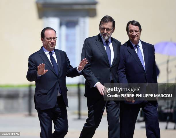 French President Francois Hollande , Spanish Prime Minister Mariano Rajoy and Cypriot President Nicos Anastasiades chat as they walk on April 10,...