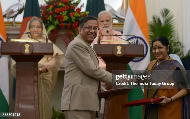 Prime Minister Narendra Modi and Bangladesh Prime Minister Sheikh Hasina watch as Foreign Minister Sushma Swaraj exchange a memorandum of...