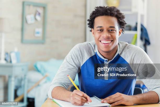 happy african american student works on homework - college preparation stock pictures, royalty-free photos & images