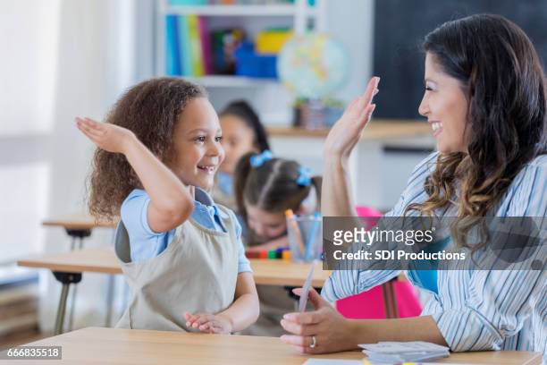 proud teacher gives student a high five in math class - flash card stock pictures, royalty-free photos & images