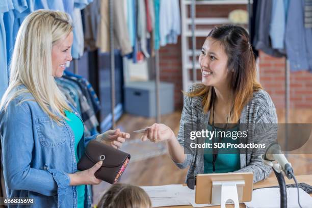 kleidung geschäft mitarbeiter akzeptiert kredit- oder kundenkarten kundenkarte - bonuskarte stock-fotos und bilder