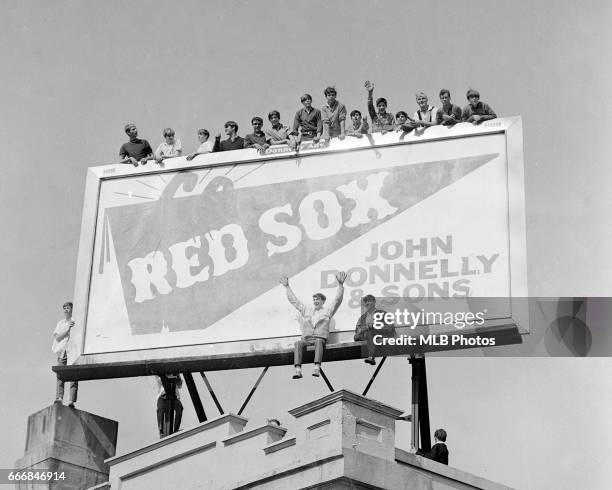 Fans watch Game 2 of the 1967 World Series between the St. Louis Cardinals and the Boston Red Sox at Fenway Park from a billboard on Wednesday,...