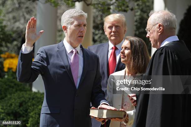 Supreme Court Associate Justice Anthony Kennedy administers the judicial oath to Judge Neil Gorsuch as his wife Marie Louise Gorshuch holds a bible...