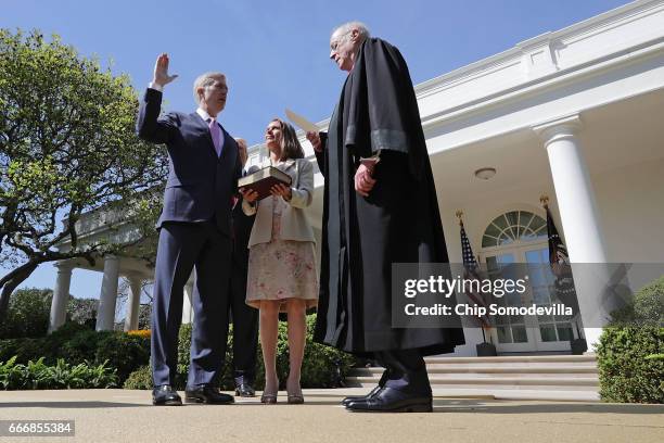 Supreme Court Associate Justice Anthony Kennedy administers the judicial oath to Judge Neil Gorsuch as his wife Marie Louise Gorsuch holds a bible...