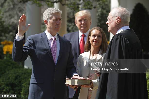 Supreme Court Associate Justice Anthony Kennedy administers the judicial oath to Judge Neil Gorsuch as his wife Marie Louise Gorsuch holds a bible...