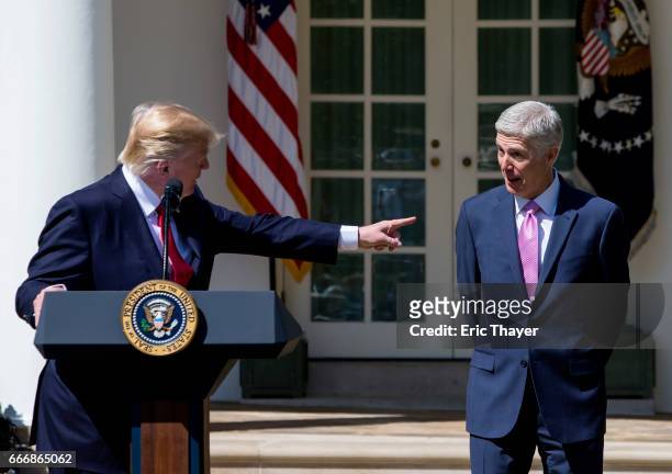 President Donald Trump points to U.S. Supreme Court Associate Justice Neil Gorsuch during a ceremony in the Rose Garden at the White House April 10,...