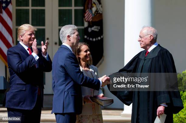 Supreme Court Associate Justice Anthony Kennedy shakes hands with Associate Justice Neil Gorsuch as his wife Marie Louise Gorshuch and President...