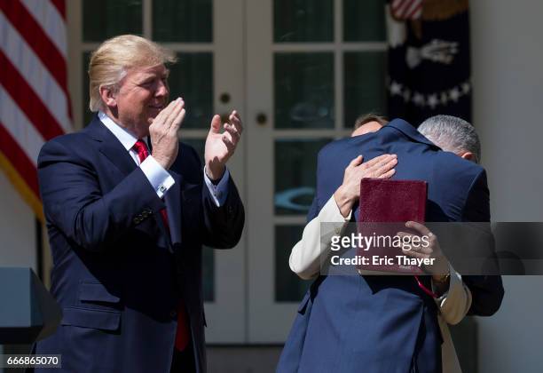 Supreme Court Associate Justice Neil Gorsuch hugs his wife Marie Louise Gorshuch as President Donald Trump looks on during a ceremony in the Rose...