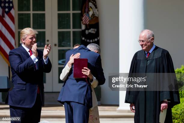Supreme Court Associate Justice Judge Neil Gorsuch hugs his wife Marie Louise Gorshuch as Associate Justice Anthony Kennedy and President Donald...