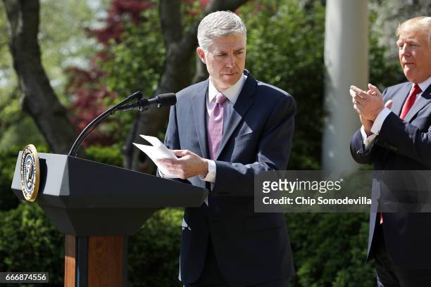President Donald Trump applauds as Supreme Court Associate Justice Neil Gorsuch delivers remarks after taking the judicial oath during a ceremony in...