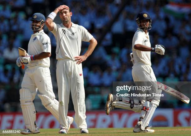 Indian batsmen Rahul Dravid and MS Dhoni take a run as New Zealand bowler Andy McKay looks in disgust on the second day of the third test match...