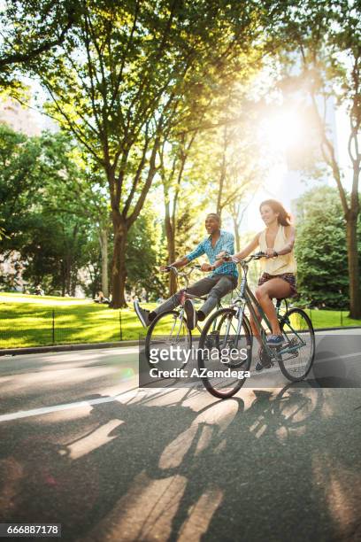 riding bicycles at central park - couple cycling stock pictures, royalty-free photos & images
