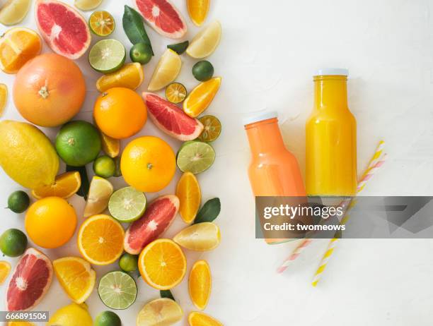 assorted citrus fruits and juice in bottles. - fruchtsaft stock-fotos und bilder