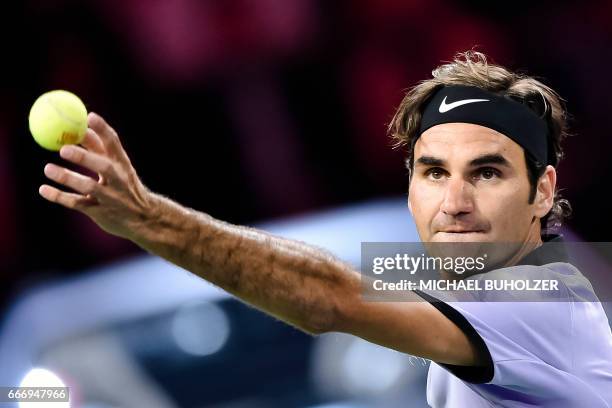 Swiss tennis player Roger Federer serves the ball to British player Andy Murray during a charity tennis match on April 10, 2017 in Zurich. "The Match...