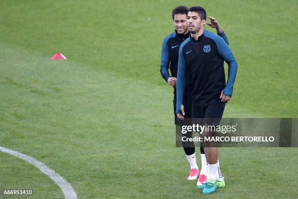 Barcelona's forward Luis Suarez from Uruguay and Barcelona's forward Neymar from Brazil take part in a training session on the eve of the UEFA...