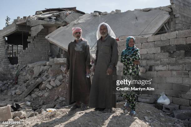 Iraqis watch Iraqi forces pass their destroyed house in Al Yarmuk, west Mosul, April 10, 2017. Iraqi forces retook the district. While Coalition air...