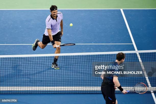 Swiss tennis superstar Roger Federer returns the ball to world number one Britain's Andy Murray during a charity match "The Match for Africa 3" on...