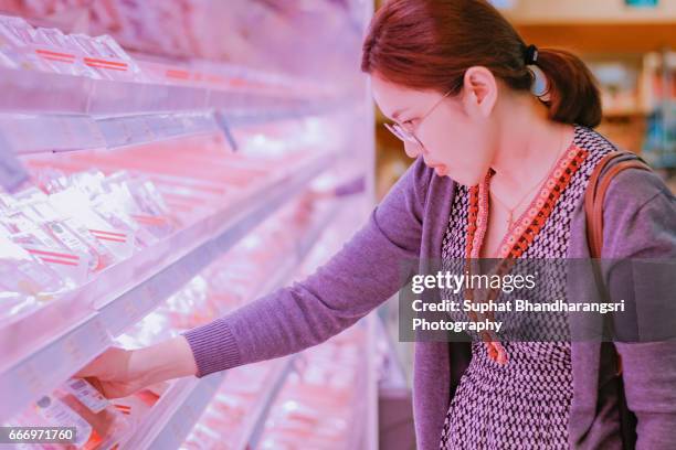 woman picking fresh meat from the shelf - suphat bhandharangsri stock pictures, royalty-free photos & images