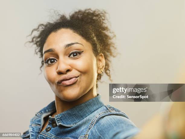 junge afrikanische frau macht ein lustiges gesicht und macht selfie - funny black girl stock-fotos und bilder