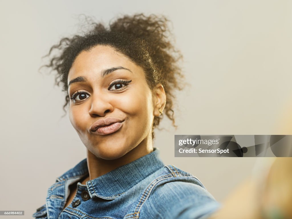 Young African Woman Making A Funny Face And Taking Selfie High-Res Stock  Photo - Getty Images