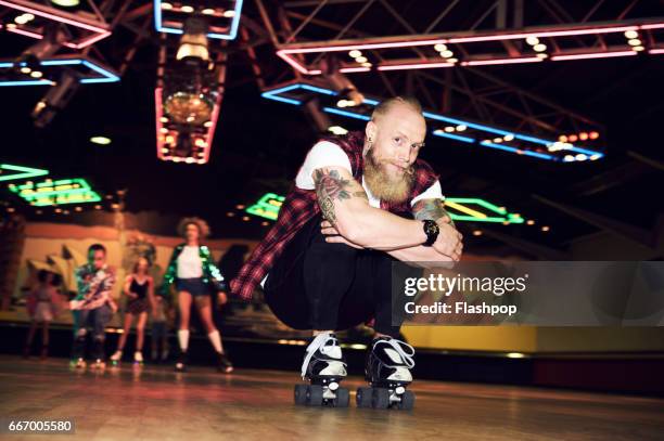 man having fun at roller disco - rolschaatsen schaats stockfoto's en -beelden