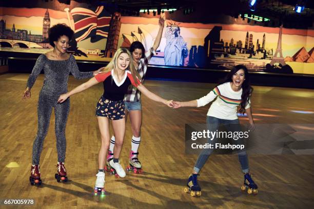 friends having fun at roller disco - roller rink stock-fotos und bilder