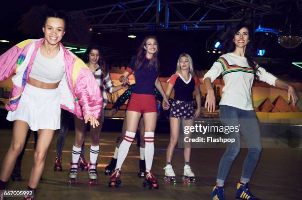 friends having fun at roller disco - roller rink stock-fotos und bilder