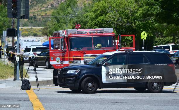 Police vehicle stands at a closed-off street outside the North Park Elementary School in San Bernadino, California on April 10, 2017 after a gunman...