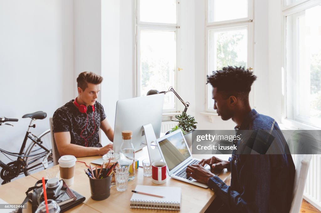 Designers working at desk in small office