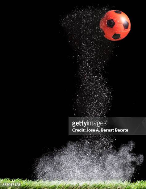ball of  soccer ball bouncing on a surface of  grass with a cloud of powder for the impact - términos deportivos foto e immagini stock