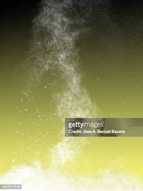explosion of a cloud of powder of particles of white color on a green background - etéreo stockfoto's en -beelden