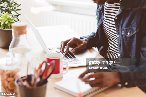 jonge man die op laptop werkt en het maken van notities - invoerapparaat stockfoto's en -beelden