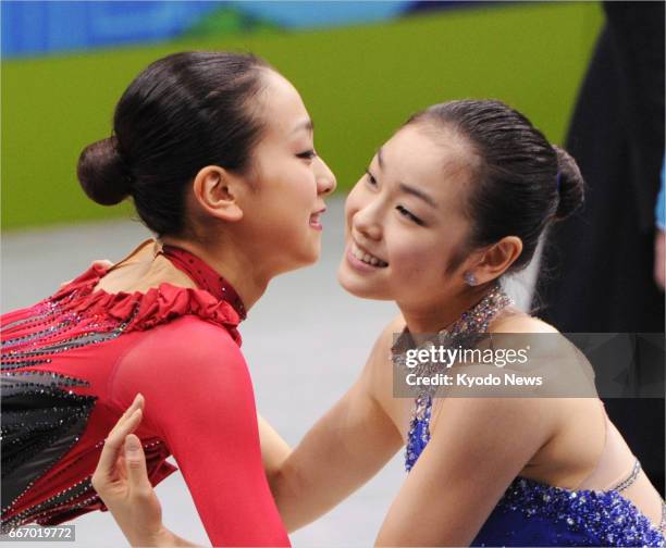 Gold medalist Kim Yu Na of South Korea and second placed Mao Asada of Japan embrace each other during the award ceremony for the women's singles...