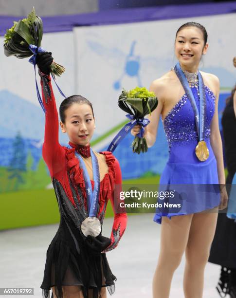 Gold medalist Kim Yu Na of South Korea and second placed Mao Asada of Japan celebrate on the podium during the award ceremony for the women's singles...