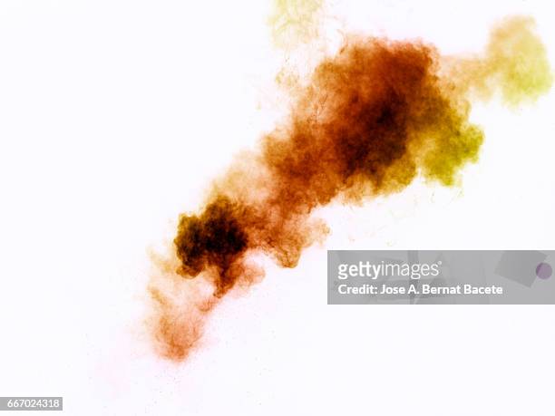 explosion of a cloud of powder of particles of  colors red and orange on a white background - etéreo stockfoto's en -beelden