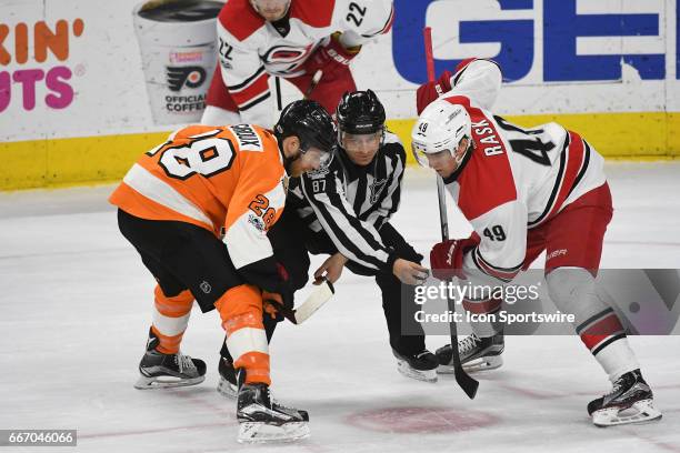 Linesman Devin Berg gets ready to drop the puck for Philadelphia Flyers Center Claude Giroux and Carolina Hurricanes Center Victor Rask during a...