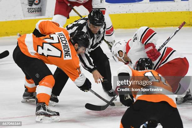 Linesman Devin Berg drops the puck for Philadelphia Flyers Center Mike Vecchione and Carolina Hurricanes Center Derek Ryan during a National Hockey...