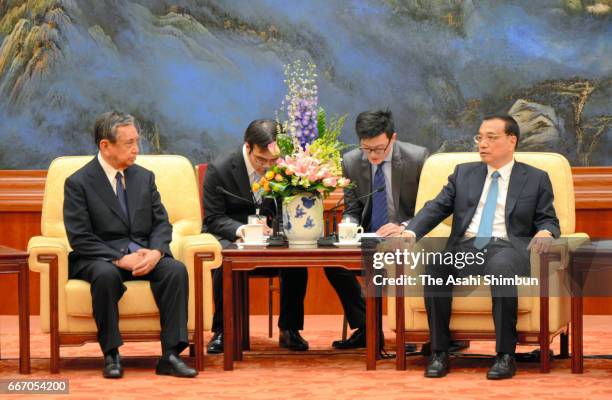 Chinese Premier Li Keqiang speaks with Yohei Kono, head of the Japanese Association for the Promotion of International Trade, during their meeting at...