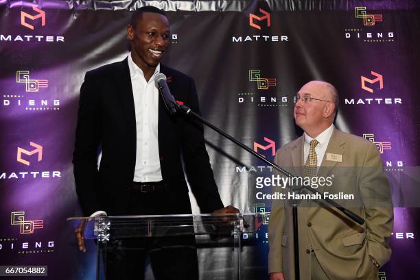 Gorgui Dieng of the Minnesota Timberwolves speaks to those in attendance while Bill Popp, Minority Owner of the Minnesota Timberwolves looks on...