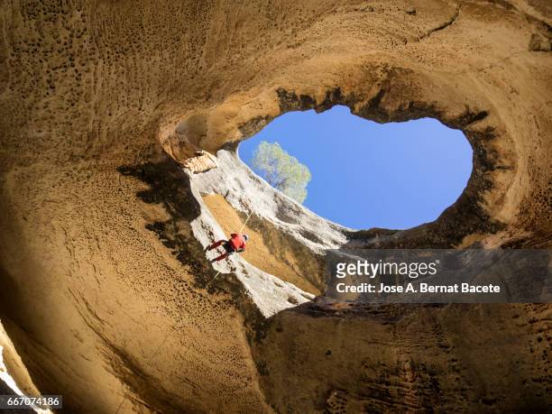climbing speleologist, descending for the interior of a cave - agujero stock-fotos und bilder