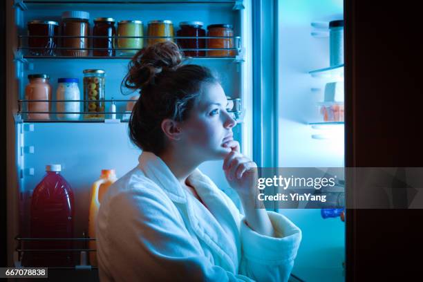 dieet jonge vrouw late nacht maken keuzes over wat te eten - fridge full of food stockfoto's en -beelden