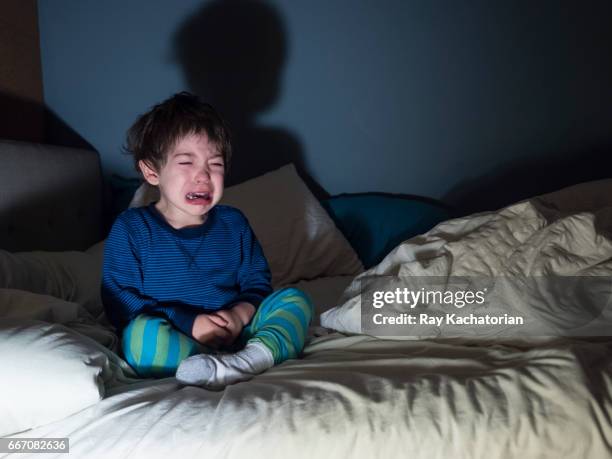 boy sitting on bed crying - toddler crying stock pictures, royalty-free photos & images
