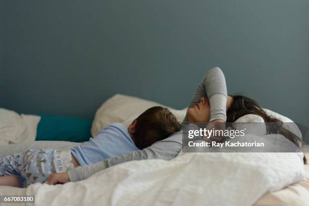 toddler and mother napping - mother sleeping child stock-fotos und bilder