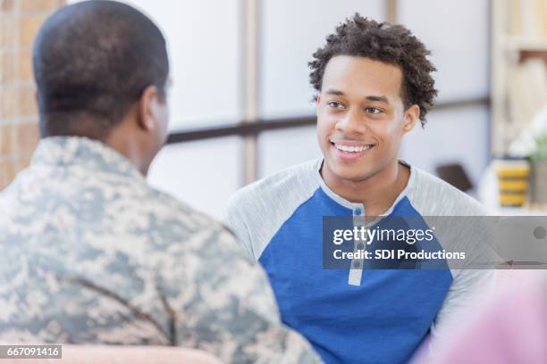 young man talks about military service with recruitment officer - military recruitment stock pictures, royalty-free photos & images