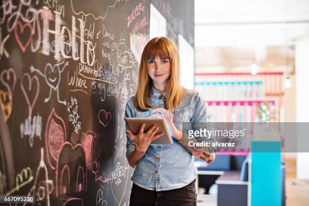 geschäftsfrau mit digital-tablette von blackboard - creative occupation stock-fotos und bilder